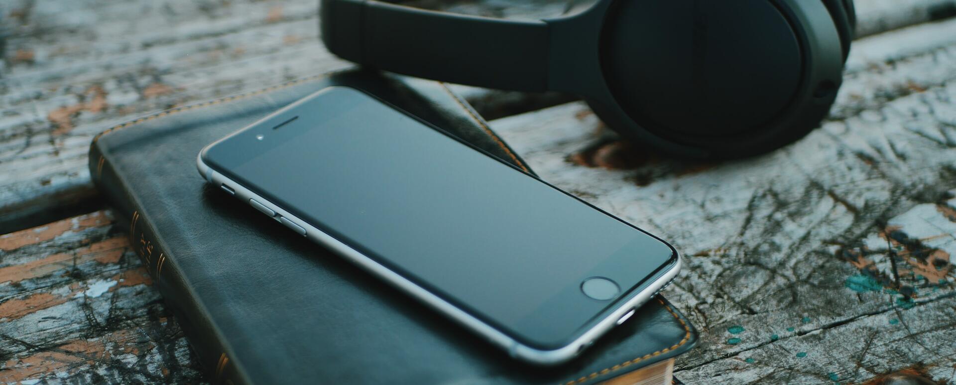 Phone, Bible and headphones on top of the desk