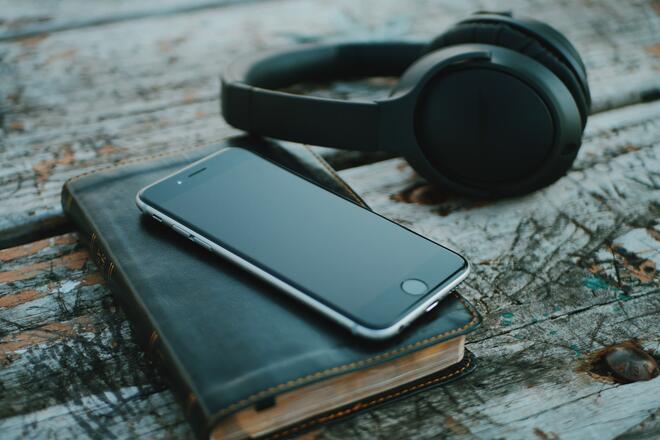 Phone, Bible and headphones on top of the desk